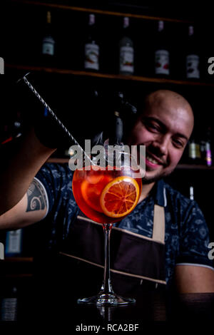 Barman messa a bicchiere di fresco e gustoso Aperol siringa pace cocktail di ghiaccio Foto Stock