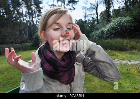 Jungendliche Frau Marienkäfer mit auf der Nase | giovane donna avente un beatle sul naso Foto Stock