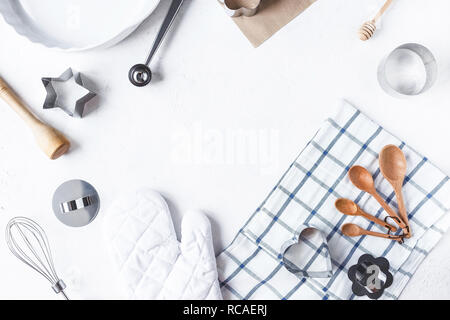La composizione della struttura delle stoviglie e accessori da cucina per la cottura sul tavolo di cucina su uno sfondo bianco spazio copia Foto Stock