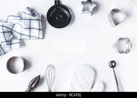 La composizione della struttura delle stoviglie e accessori da cucina per la cottura sul tavolo di cucina su sfondo bianco Foto Stock