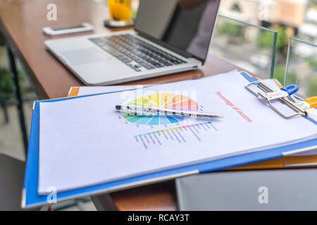 Relazione finanziaria, laptop e la penna sul banco di lavoro Foto Stock