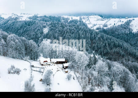 Tradizionale paesaggio invernale in Romania nel villaggio Sirnea, Transilvania, nelle montagne dei Carpazi Foto Stock