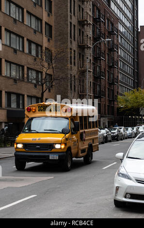 La città di New York, Stati Uniti - 17 Novembre 2018: un colore scegli la foto di una scuola di New York autobus a esso trascina verso West 56th Street Foto Stock