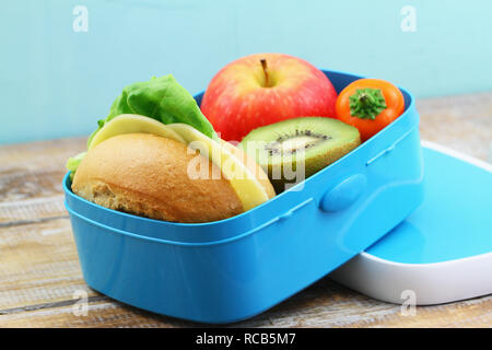 Pranzo al sacco contenente formaggio rotolo, croccante di peperone giallo e frutta fresca: Rosso mela e kiwi Foto Stock