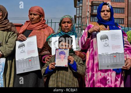 I parenti di persone scomparse tenere calendari e fotografie di persone scomparse durante un rilascio del calendario a Srinagar, Indiano Kashmir amministrato. A partire dal gennaio 2016, l'Associazione dei Genitori degli scomparsi i genitori (APDP) ha pubblicato il suo calendario annuale, che chiama "un documento di memoria". Il calendario è un collage di bozzetti realizzati da fotografie di uomini desaparecidos nelle mani dello Stato, insieme con i dettagli della loro scomparsa. Foto Stock