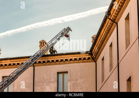 Ravenna, Italia. Il 15 gennaio, 2019. Un coraggioso pompiere controlla i danni causati dal terremoto e rimuove il pericoloso tegole del tetto dal membro Archivio storico edificio. Per motivi di sicurezza, a causa del terremoto, diversi edifici pubblici, comprese le scuole statali e gli archivi storici, oggi chiusi. GoneWithTheWind/Alamy Live News Foto Stock