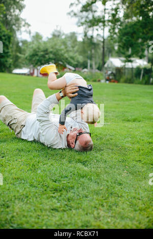 Nonno giocando con il nipote sul prato Foto Stock