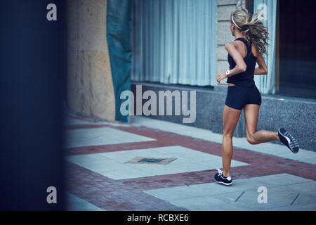 Donna jogging in città Foto Stock