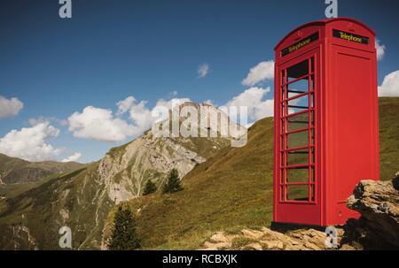 Telefono rosso nella casella vicino a Mont Blanc, Francia in estate erba Foto Stock