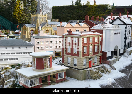 La stazione della metropolitana, l'ufficio postale e la chiesa nella città nuova a Bekonscot Model Village, Beaconsfield, Buckinghamshire, Regno Unito. In inverno neve. Foto Stock