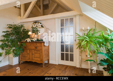 Antico legno di acero cassettiera e piante verdi in camera da letto principale al piano attico di un antico circa 1840 Canadiana cottage in stile home Foto Stock