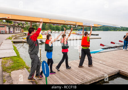 Trakai, Lituania - 26 Luglio 2013: turisti che trasporta un otto che è una barca a remi usato nello sport competitivo di canottaggio. Questo estive turistiche att Foto Stock