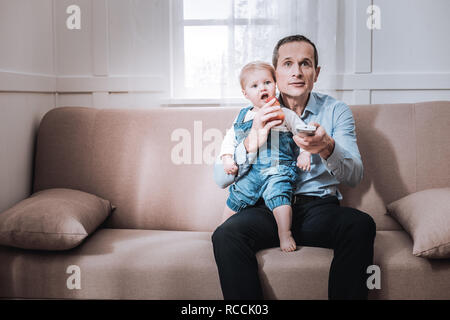 Nizza uomo positivo guardare la TV Foto Stock