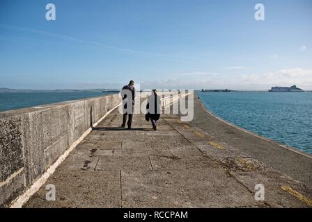 Un uomo e una donna a piedi lungo la scogliera di Holyhead, Holyhead, Anglesey, Galles del Nord, Regno Unito Foto Stock