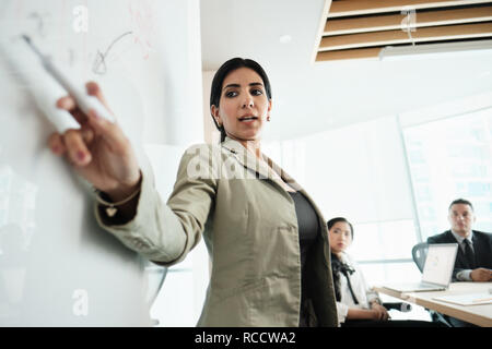 Donna facendo presentazione con bordo in Office Sala Riunioni Foto Stock