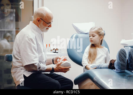 Incantevole piccola ragazza seduta in studio dentistico Foto Stock