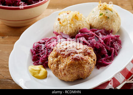 Frikadellen tedesco, una piccante polpetta di carne macinata o di vitello con canederli e triturato di cavolo rosso su una targhetta ovale Foto Stock