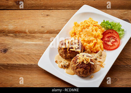 Due frikadellen bavarese o polpette di massa o macinata carne piccante servito con patate e carote blend guarnita con insalata Foto Stock