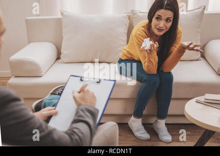 Dai capelli scuri donna giovane sentirsi deluso visitando psicologo Foto Stock