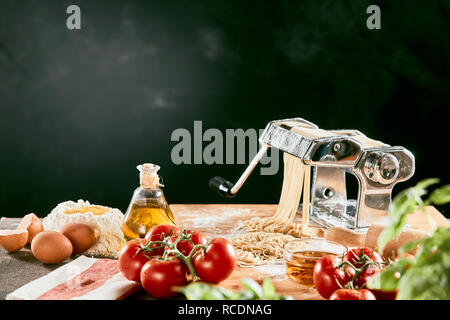 Specialità fatte in casa pasta italiana con ingredienti per una cucina tradizionale mediterranea su un tavolo da cucina Foto Stock