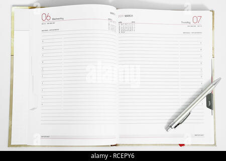 Foto della penna sul diario del vuoto. Isolato su uno sfondo bianco. Foto Stock