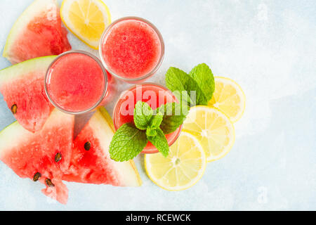 Lay piatto con tre bicchiere di anguria mojito su th sfondo blu con spazio di copia Foto Stock