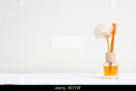 Reed aromatico rinfrescante, diffusore di fragranze Set di bottiglia con bastoni di aroma (reed diffusori) sul muro bianco sullo sfondo. Foto Stock