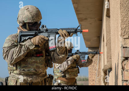 Nuova Zelanda soldati da Gruppo attività Taji utilizzare aria soft fucili con munizioni simulato alla pratica urbana di Trapani del gioco prima di erogare la formazione di forze di sicurezza irachene gli istruttori a Baghdad scuola di combattimento Camp Taji, Iraq, nov. 27, 2018. Come parte di questa missione, in Australia e Nuova Zelanda personale offrono formazione di vitale importanza per le Forze di Sicurezza Irachene come essi continuano a condurre l'operazione contro la minaccia di estremismo violento e di garantire la stabilità nelle regioni che vengono ora cancellati di Daesh. In collaborazione con le forze di partner, Combined Joint Task force - Funzionamento inerenti Foto Stock