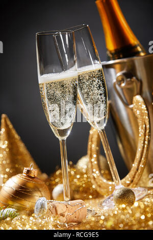 Anno nuovo card con due flauti champagne circondato da golden Ornamenti natale durante il party romantico o celebrazione a mezzanotte Foto Stock