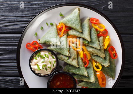 Gli spinaci vegetariana samosa con salse close-up su una piastra sul tavolo. Parte superiore orizzontale vista da sopra Foto Stock