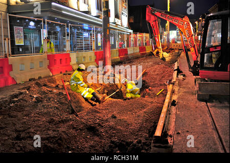 Due ingegneri che lavorano sul Blackpool estensione del tram di notte Foto Stock