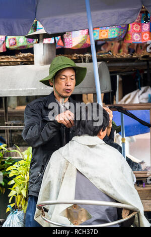 Barbiere il taglio di capelli a Bac Ha domenica Mercato nel nord del Vietnam Foto Stock