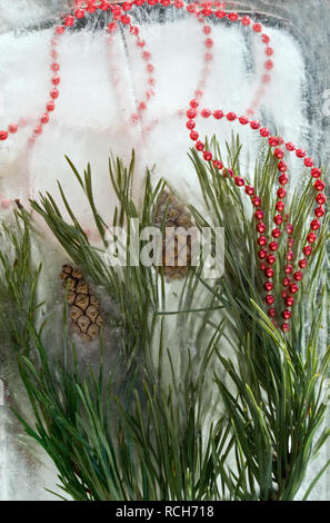 Sfondo rosso di perle, stella di Natale, il cono ramoscello di pino in cubetti di ghiaccio con bolle di aria.Felice anno nuovo 2019 greeting card . Spazio di copia, t Foto Stock