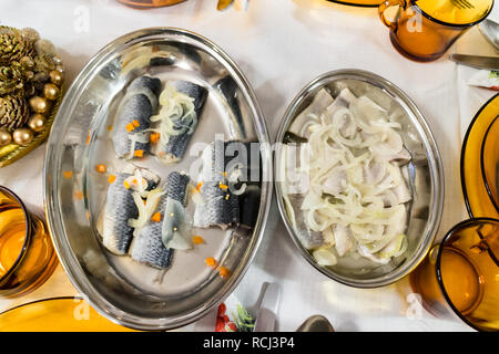 Aringhe in salamoia con cipolla nel recipiente sul tavolo Foto Stock