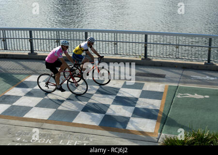 Due ciclisti sul lungofiume e cycleway marciapiede, Brisbane, Queensland, Australia Foto Stock