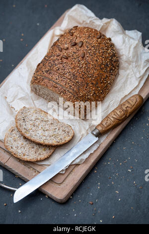 Seminate il pane con un vintage Coltello per pane su un pane a bordo. Regno Unito Foto Stock