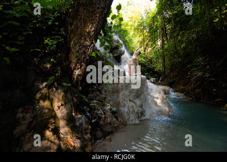 Tropical sessione di yoga da una bella cascata appiccicosa vicino a Chiang Mai nel nord della Thailandia. camel pongono: Ardha Ustrasana Foto Stock