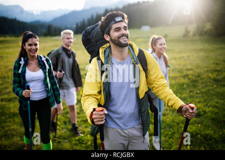 Avventura, viaggi, turismo, escursione e concetto di persone - gruppo di amici sorridente con zaini e mappa all'aperto Foto Stock