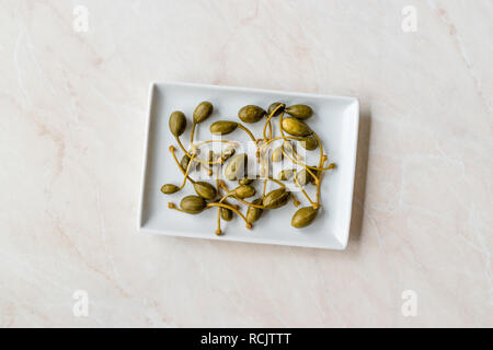 Decapati e conserve di capperi pronto a mangiare nella piastra. Alimenti biologici. Foto Stock