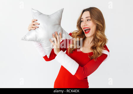 Ritratto di donna felice 20s indossando Santa Claus costume rosso sorridente e tenendo a forma di stella cuscino isolato su sfondo bianco Foto Stock