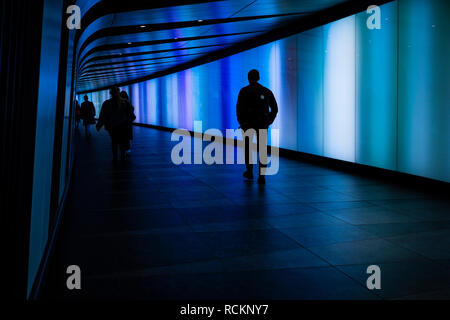 In stile futuristico tunnel pedonale dotato di un LED luminoso integrato nella parete granaio uscita quadrata da Kings Cross, London Foto Stock