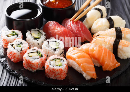 Varietà di sushi cibo. nigiri, Maki, uramaki e rotolo con tonno, salmone e gamberetti. Tradizionale cibo asiatico con pesce crudo e riso. orizzontale Foto Stock