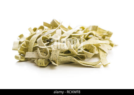 Materie pasta italiana. Asciugare le tagliatelle con spinaci isolati su sfondo bianco. Foto Stock