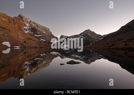 La riflessione del monte Baldwin e ardesia rosso Montagne in Bright Dot Lago dopo il tramonto nelle montagne della Sierra Nevada Foto Stock