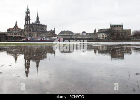 Dresden, Germania. 16 gennaio, 2019. La chiesa cattolica chiesa di corte (l) e la Semper Opera House sono riflessi nell'acqua del fiume Elba. Il disgelo tra le montagne e la pioggia hanno causato alcuni fiumi in Sassonia a gonfiarsi. Credito: Sebastian Kahnert/dpa-Zentralbild/ZB/dpa/Alamy Live News Foto Stock