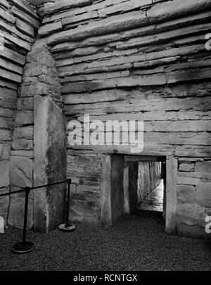 Vista interna della camera centrale di Maes Howe Neolitico chambered cairn, isole Orcadi Scozia, Regno Unito, mostrando ingresso interna passaggio & angolo sud contrafforte. Foto Stock