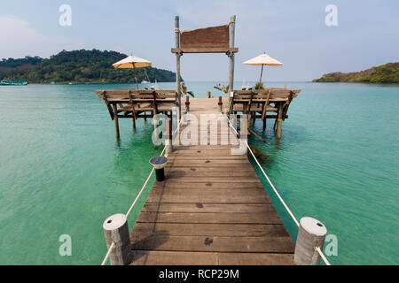 Paesaggio estivo sulla tropicale Koh Kood island in Thailandia. Paesaggio con un lungo molo in legno presi su Bang Bao beach. Foto Stock