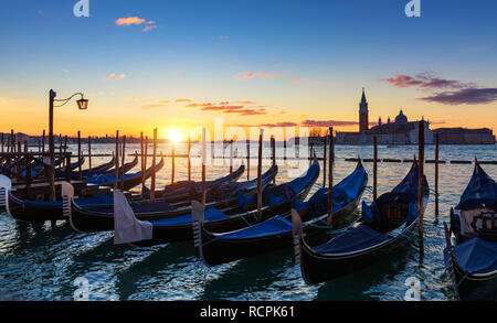 Vista panoramica di San Giorgio Maggiore, le gondole e lampada colorata a sunrise, Venezia, Italia. Tramonto a Venezia. Gondole in Piazza San Marco e churc Foto Stock