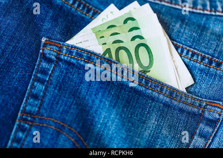 Le fatture in euro in tasca dei jeans sfondo. Le banconote in euro in jeans tasca posteriore. Concetto di gente ricca, salvataggio o spendere soldi. Euro Bills cadano fuori. Foto Stock