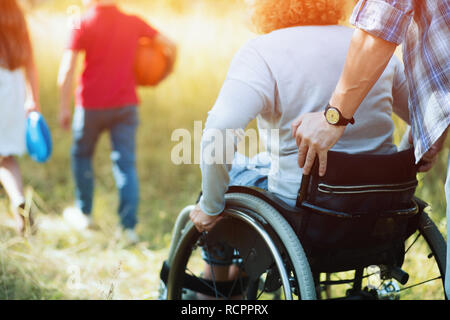 Close up guarda su una donna torna su una sedia a rotelle. Foto Stock